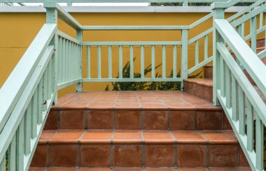 Yeşil demir parmaklıklı kahverengi beton merdiven