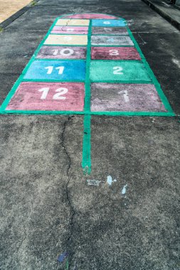 Çocuklar beton zemine boyanmış seksek oyunu