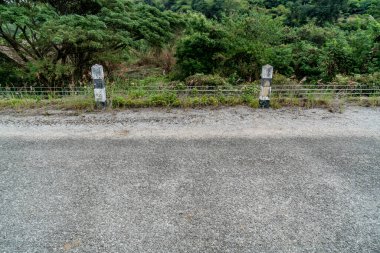 Köy yolunda siyah-beyaz beton trafik direği