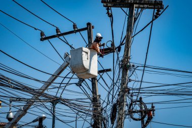 Elektrik direğiyle çalışan adam.