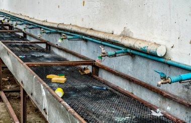 Eski beton duvardaki musluk sırası