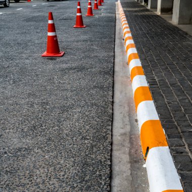 Sarı ve beyaz kaldırımlı beton kaldırım ve turuncu trafik konileri