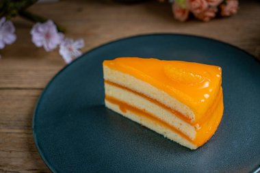 Koyu mavi seramik tabakta turuncu kek.