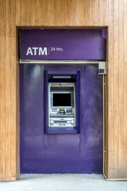 Ahşap duvarda mor ATM makinesi