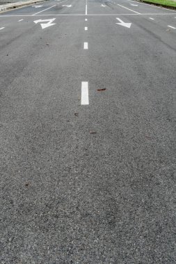 Ok işareti ve beyaz nokta çizgisi olan asfalt yolu