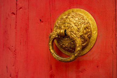 Altın Çinli kapı kolu kırmızı ahşap kapıda.