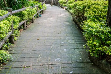 Parkta korkulukların olduğu beton yol