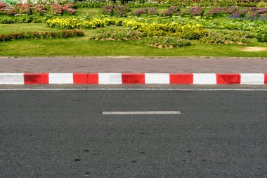 Kaldırımda kırmızı ve beyaz trafik işaretli asfalt yol