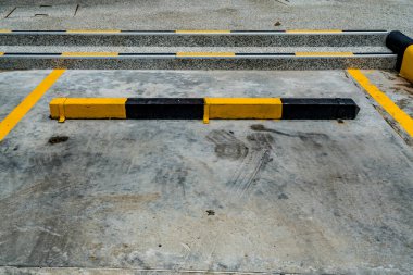 Siyah ve sarı kaldırımlı boş bir otopark.