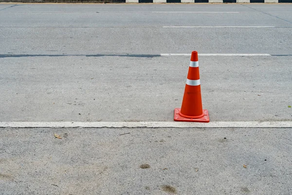 Plastic orange cone on the asphalt road