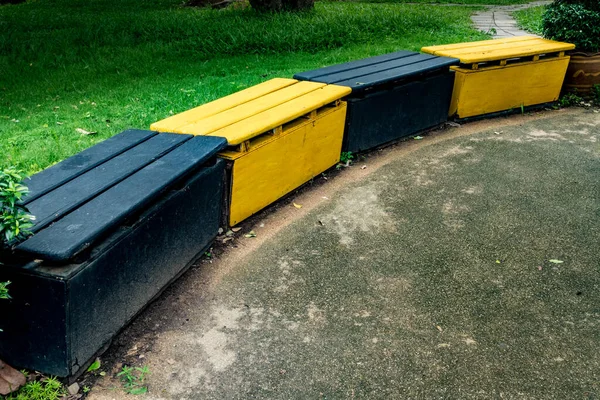 Parkın Beton Zemininde Siyah Sarı Ahşap Banklar — Stok fotoğraf