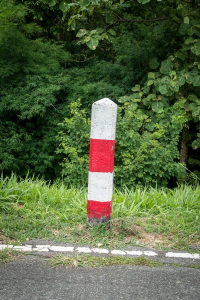 乡村道路上的红白两色混凝土交通杆 — 图库照片