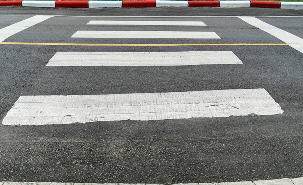 歩道の縁石に赤と白の標識とアスファルトの道路上の空の横断歩道 — ストック写真