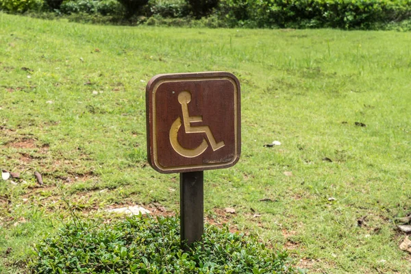 緑の芝生の床に木製の障害者標識 — ストック写真