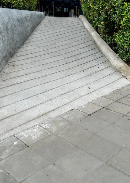 Concrete ramp for wheelchair with trimmed plants