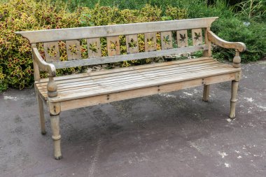 Bahçede beton zeminde ahşap park bankı
