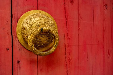 Altın Çinli kapı kolu kırmızı ahşap kapıda.