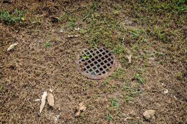 Kuru çimenlerin üzerindeki paslı metal gideri