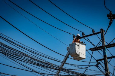 Elektrik direğiyle çalışan adam.