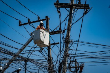 Elektrik direğiyle çalışan adam.