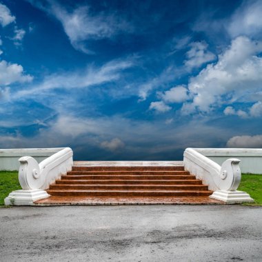 Beton merdiven ve mavi gökyüzü zeminli beyaz beton parmaklık.