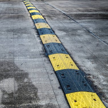 Beton yolda sarı ve siyah hız tümseği