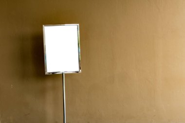 Kahverengi beton arka planda paslanmaz çerçeveli boş beyaz tahta