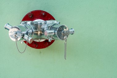 Yeşil beton duvarda yangın musluğu