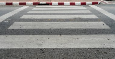 Kaldırımda kırmızı ve beyaz işareti olan asfalt yolda boş yaya geçidi