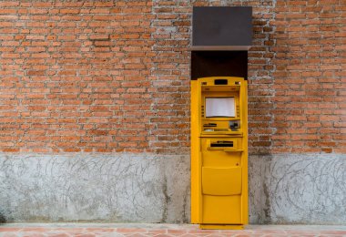 Beton duvarda sarı ATM makinesi