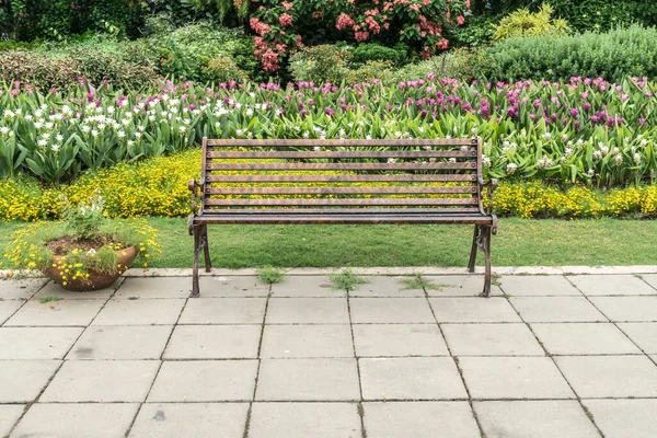 Metal park bench on concrete floor in the park