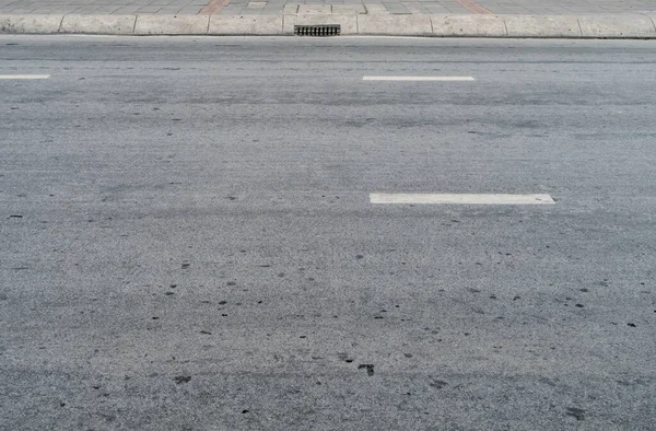 Asphalt road with metal drain cover