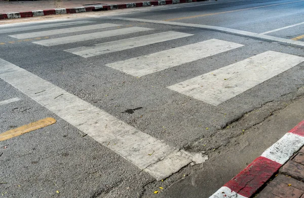 人行道路边有红白标志的沥青路面交叉口的景观 — 图库照片