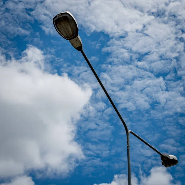 Street light pole on white cloud and blue sky