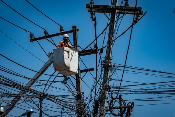 Man working with electricity power line pole