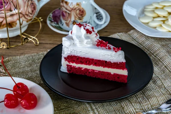 Slice red velvet cake with spoon on black plate