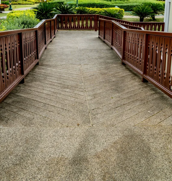 Concrete ramp for wheelchair with wooden railing