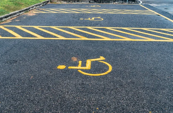 Handicapped sign on the asphalt road in car park