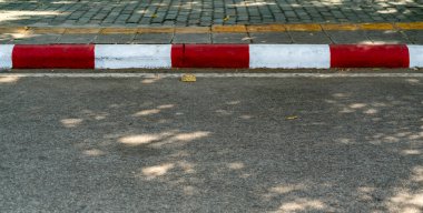 Kırmızı ve beyaz kaldırımlı asfalt yol