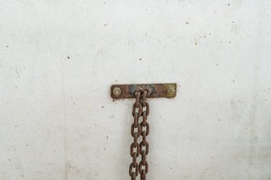 Paslı zincirli beyaz beton duvar