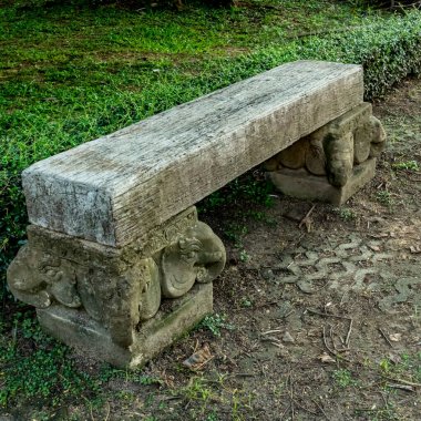 Parktaki beton bloktaki eski ahşap bankta.