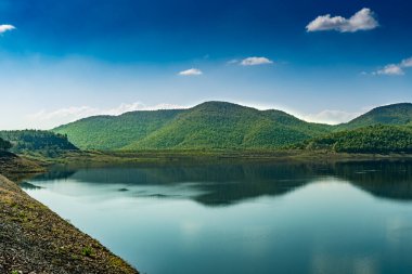 Mavi arka planda dağlı göl
