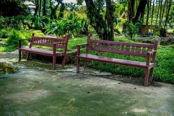 Wood park bench on concrete floor in garden