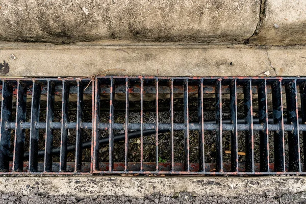 Rusty metal drain cover on the road