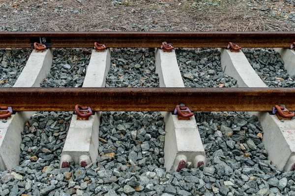 灰色の砂利上のラスティ鉄道線路の視点 — ストック写真