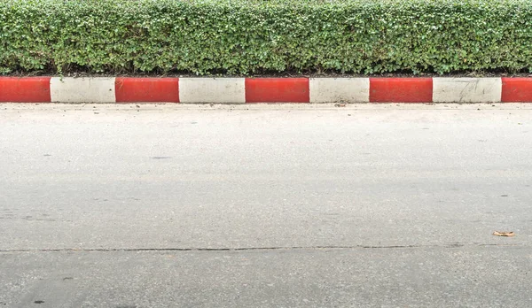 Concrete road with red and white curb