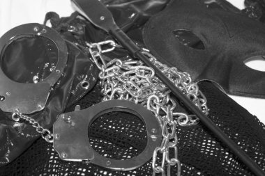 Siyah bdsm erotik oyuncaklar, kırbaç, göz maskesi, zincir, el manşetleri, zevk seks kavramı fotoğraf. Fetiş erotik bdsm kavramsal görüntü.