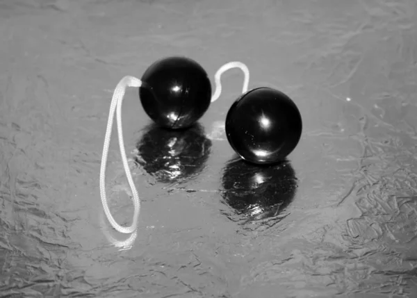 Простые дешевые черные вагинальные любовные шары на серебряной блестящей поверхности. Секс-игрушка . — стоковое фото