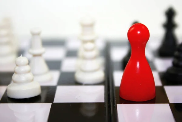 Belo contraste preto e branco com a figura de ludo vermelho no tabuleiro de xadrez. Foto de jogo de liderança conceitual . — Fotografia de Stock