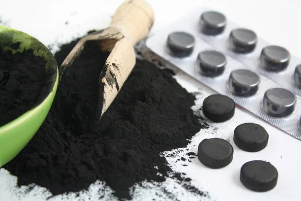 Активоване вугілля таблетки чорного порошку абсорбують — стокове фото